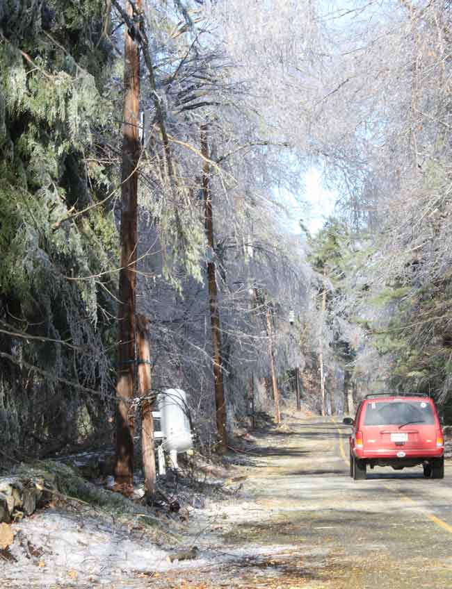 A transformer dangles a few feet off Bolton Road after the pole it was on snapped in two.