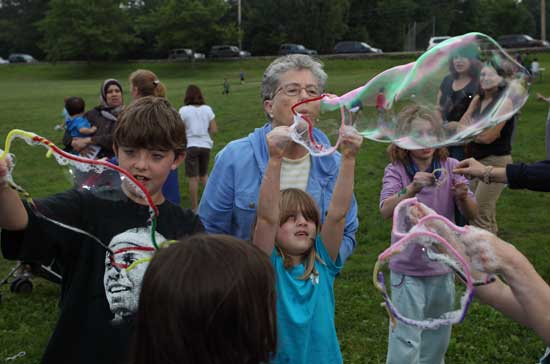 Baylor Ashe, Betty Ashe, and Annabelle Ashe blow giant bubbles together.