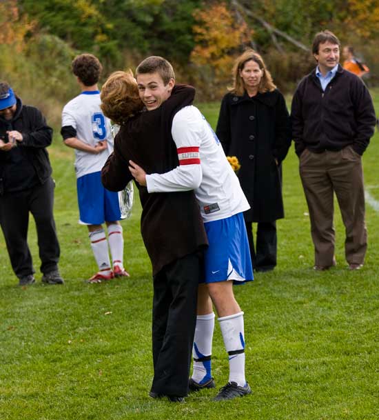 Bromfield soccer player Cody Osgood gives his mom Kelly a hug and a bouquet of flowers as part of the seniors’ ritual each season to acknowledge their parents’ support. Lori and Mark Mandozzi look on.