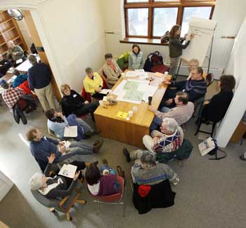 Participants sit in groups brainstorming future uses of town buildings at a charrette held in the old library on Jan. 30. (Photo by Lisa Aciukewicz)