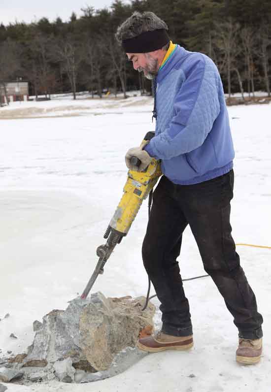 Tom Cotton breaks up a rock in Bare Hill Pond in an effort to clear the pond of boat-damaging rocks that lie just below the surface.