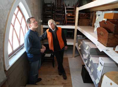 Board members Denis Wagner and Doug Slade look over a new storage space created on the second floor of the Harvard Historical Society during renovations after last fall’s fire. (Photo by Lisa Aciukewicz)