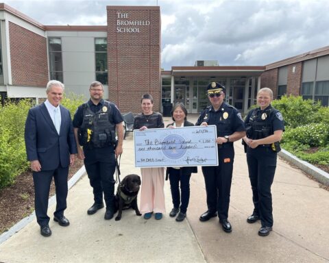 Six people standing outside the Bromfield School holding a large check in the amount of $1200