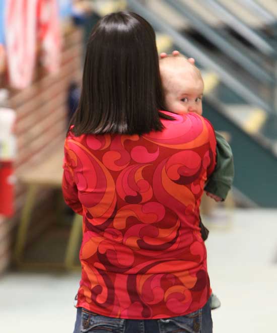 Performer Miki Fitzgibbons walks her son, Carter, after her performance.