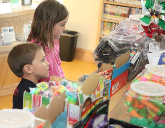 Aidan Long and his cousin, Meadow Hatch, check out the summer reading rewards at the library.
