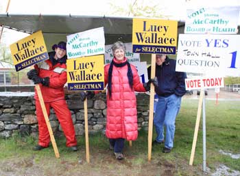 Tim Clark, Lucy Wallace, and Ken Ashe greet voters in front of Bromfield on a rainy Tuesday. (Photo by Lisa Aciukewicz)